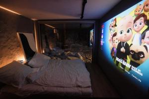 a bedroom with a bed and a large screen at KONTAINERLOFT in Laz