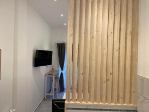 a wooden partition in a room with a tv at Les Bulles de Mona "Le 149" -PROXIMITE GARE DE LYON- in Lyon