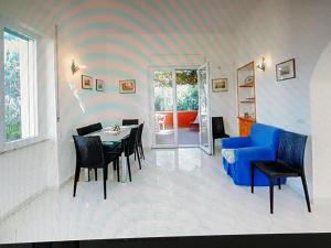 a living room with a blue couch and a table and chairs at Elegante e centralissimo appartamento in villa in Ischia +7 photos