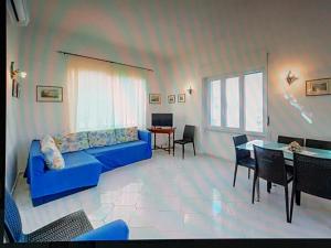 a living room with a blue couch and a table at Elegante e centralissimo appartamento in villa in Ischia