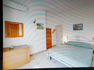 a bedroom with a bed and a striped wall at Elegante e centralissimo appartamento in villa in Ischia
