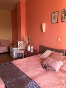 a bedroom with a bed with an orange wall at Hotel Rodini in Kato Rodini