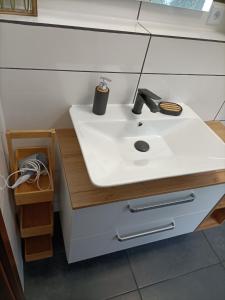 ein Badezimmer mit einem weißen Waschbecken und einer Ablage in der Unterkunft Landhaus Dahlem in Hahnenklee-Bockswiese + 37 Fotos