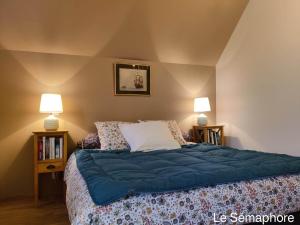 um quarto com uma cama com lençóis azuis e 2 candeeiros em Du coté de chez Swann 1 em Trouville-sur-Mer