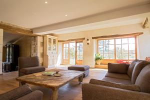 a living room with a wooden table and chairs at Le chant des pierres - douceur et nature in Les Marthres
