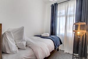 1 dormitorio con 1 cama con sábanas blancas y ventana en West Midlands Contractor - LongStay - Parking - 4 Beds - Pet Friendly, en Sleightholme