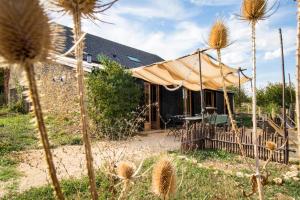 a house with a tent in front of it at Le chant des pierres - douceur et nature in Les Marthres