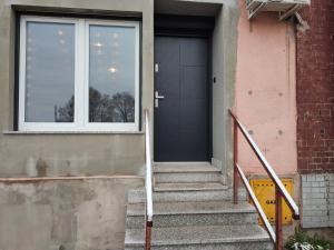 una puerta de un edificio con escaleras y una ventana en Kopalnia Szczawienko I, en Wałbrzych