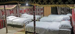 - un groupe de 4 lits dans une chambre dans l'établissement Desert Wonders Camp, à Ḩawīyah