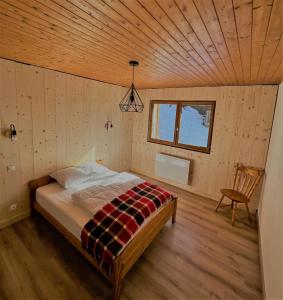 een slaapkamer met een bed in een houten kamer bij Appartement EDELWEISS in Châtel
