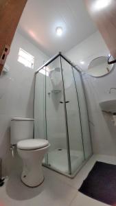 a bathroom with a toilet and a glass shower at Batera House Noronha in Fernando de Noronha