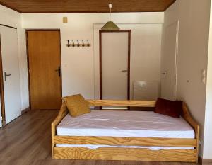 een slaapkamer met een houten bed in een kamer bij Appartement EDELWEISS in Châtel