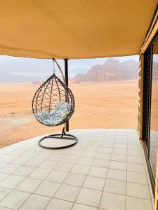 a chair on a porch with a view of the desert at Flower Life Camp in Wadi Rum