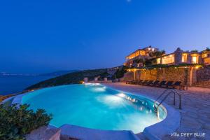a swimming pool with a view of the ocean at night at Blue Caves Villas - exceptional Villas with private pools direct access to the sea in Koríthion