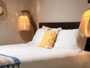 坎昆的住宿－Xaman - Boutique Studios，一张带白色床单和黄色枕头的床