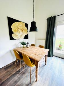 een eetkamer met een houten tafel en gele stoelen bij IJsselgoud in Zwolle
