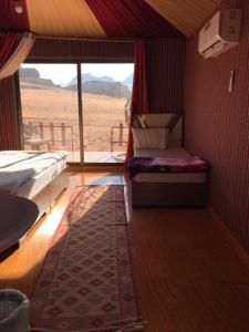 a room with a bed and a view of the desert at Flower Life Camp in Wadi Rum