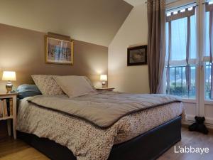 a bedroom with a bed and a large window at Du coté de chez Swann 1 in Trouville-sur-Mer