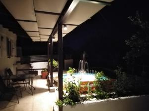 a patio at night with a fountain in the middle at Apartment 2 for rent in Tzanata Kefalonia in Dhimisianáta