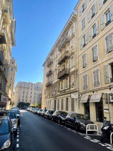 rząd samochodów zaparkowanych na ulicy obok budynków w obiekcie Magnifique 2 pièces de 65m2 -quartier des Musiciens w Nicei