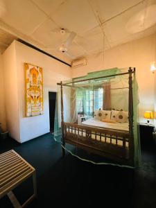 a bedroom with a canopy bed in a room at Traditional Kandyan House in Kandy
