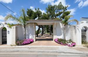 a gate to a villa with pink flowers at Casa Torre di Specchio 2 con Piscina in Bari +54 photos