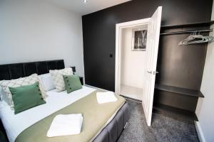 a bedroom with a large white bed with green pillows at Winter Gardens Suites by Sasco in Blackpool