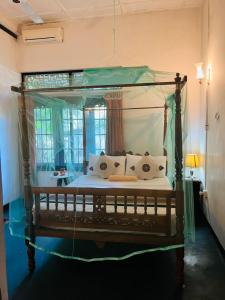 a bedroom with a canopy bed with pillows at Traditional Kandyan House in Kandy