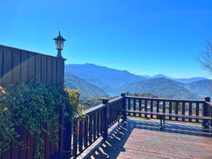 a wooden deck with a lamp on top of a mountain at Tian Hsiang Tea B&B in Ren'ai