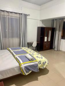- une chambre avec un lit doté d'une couverture jaune et bleue dans l'établissement Van Der Salle - Flovan Plaza, à Haatso
