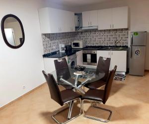 a small kitchen with a glass table and chairs at SOL AZUL in Santa Maria +14 photos