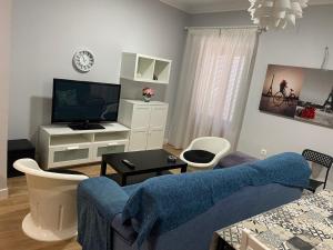 ein Wohnzimmer mit einem Sofa und einem TV in der Unterkunft Apartamento Venus in Salar