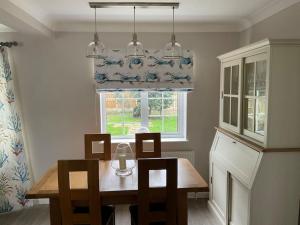 a dining room with a table and chairs and a window at Klara's House in West Mersea
