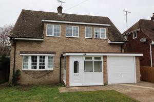 a brick house with a white garage at Klara's House in West Mersea