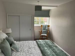 um quarto com uma cama, uma cadeira e uma janela em Klara's House em West Mersea