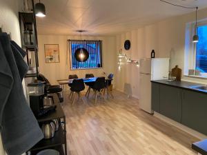 a kitchen and dining room with a table and a refrigerator at Fiskerhuset langø in Nakskov