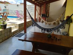 a hammock in a room with a pool at Casa Pirineus in Pirenópolis