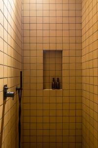 a tiled bathroom with three bottles on a shelf at DUNE DU PALACE in Zeebrugge