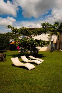a group of white chairs sitting on the grass at Finca Hotel San Angello in Quimbaya