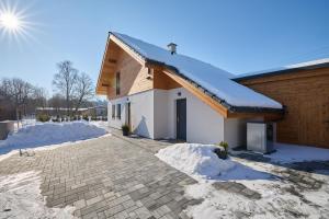una casa con techo cubierto de nieve en B-arák wellness domek pod horama, en Mladé Buky