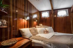 Bett in einem Zimmer mit Holzwänden und einem Tisch in der Unterkunft Spacious 24Meters Long Yacht Lagaro / 5 Cabins in Ibiza-Stadt