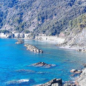 un cuerpo de agua con rocas y una montaña en Borgo cadelazzino, en Anzo