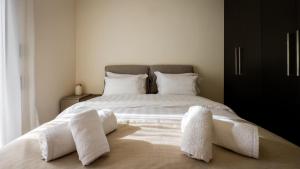 een slaapkamer met een groot wit bed en handdoeken bij Meteora Skyline by Meteora Residencies in Kalabaka