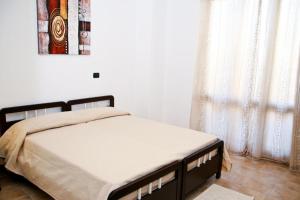 a bed in a bedroom with a picture on the wall at Villa Marogna in Alghero