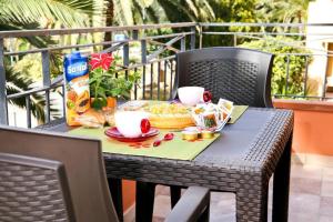 una mesa con comida y bebida en el balcón en Villa Marogna, en Alghero
