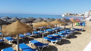 un gruppo di sedie e ombrelloni in spiaggia di Apartment Santana -19 at Beach with Pool, Garage and Lift a Torrevieja