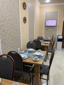 a dining room with wooden tables and chairs at Old Safari Golden Location Guest house with Laundry Service in Bukhara