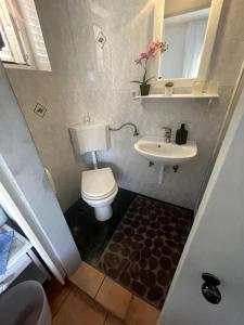 a small bathroom with a toilet and a sink at Casa Fumica Studio in Kampor