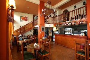 a restaurant with tables and chairs and a staircase at Hotel Regidor in Salta