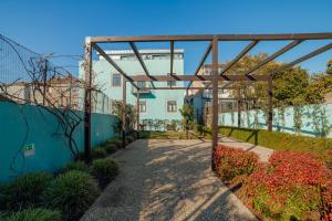 een gebouw met een pergola in een tuin bij Oporto Pool Apartment by Vacationy in Porto